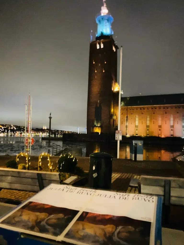 Affisch vid vattnet med Stadshuset i bakgrunden