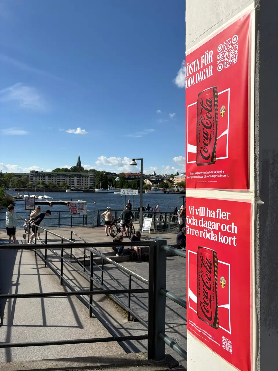 Coca-Cola-affischer Vi vill ha fler röda dagar och färre röda kort vid Lumabryggan i Hammarby sjöstad