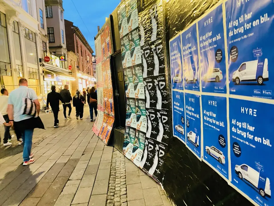 HYRE-affischer i rad längs en gågata