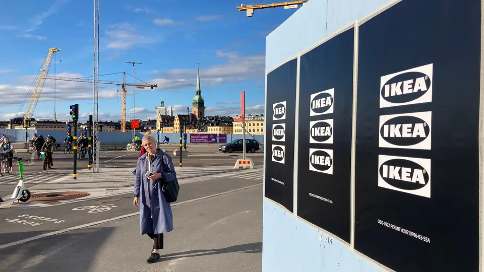 Svarta IKEA-affischer på ett byggplank vid Slussen med Gamla stan i bakgrunden