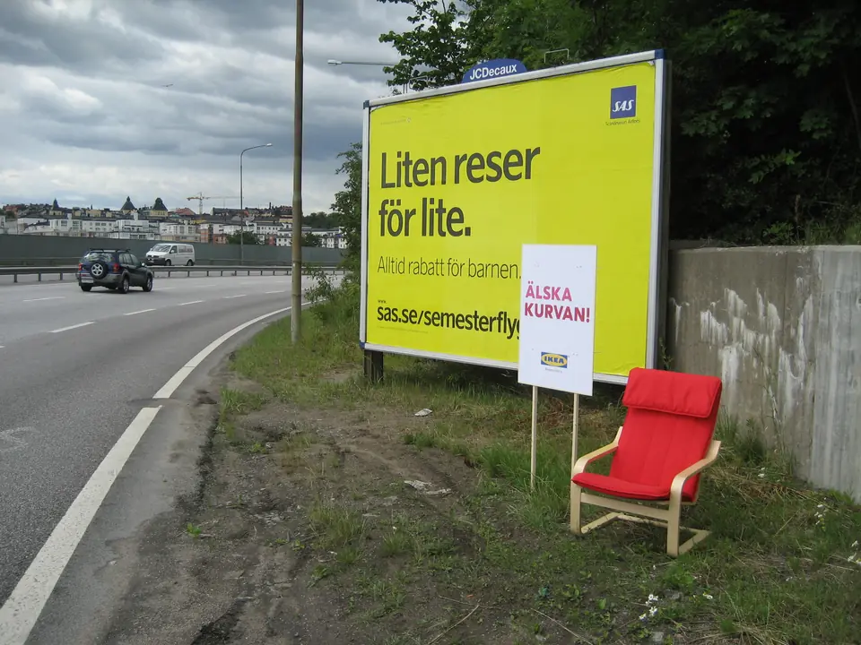 IKEA-fåtölj vid vägkanten med skylten Älska kurvan