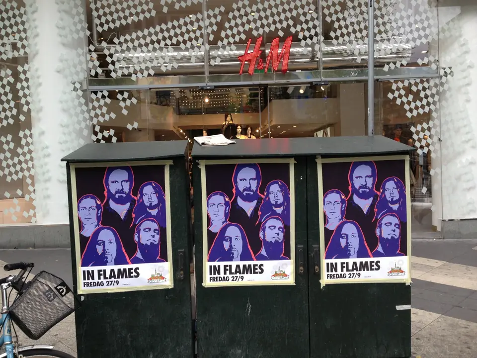Tre In Flames-affischer för Gröna Lund på elskåp framför en H&M-butik