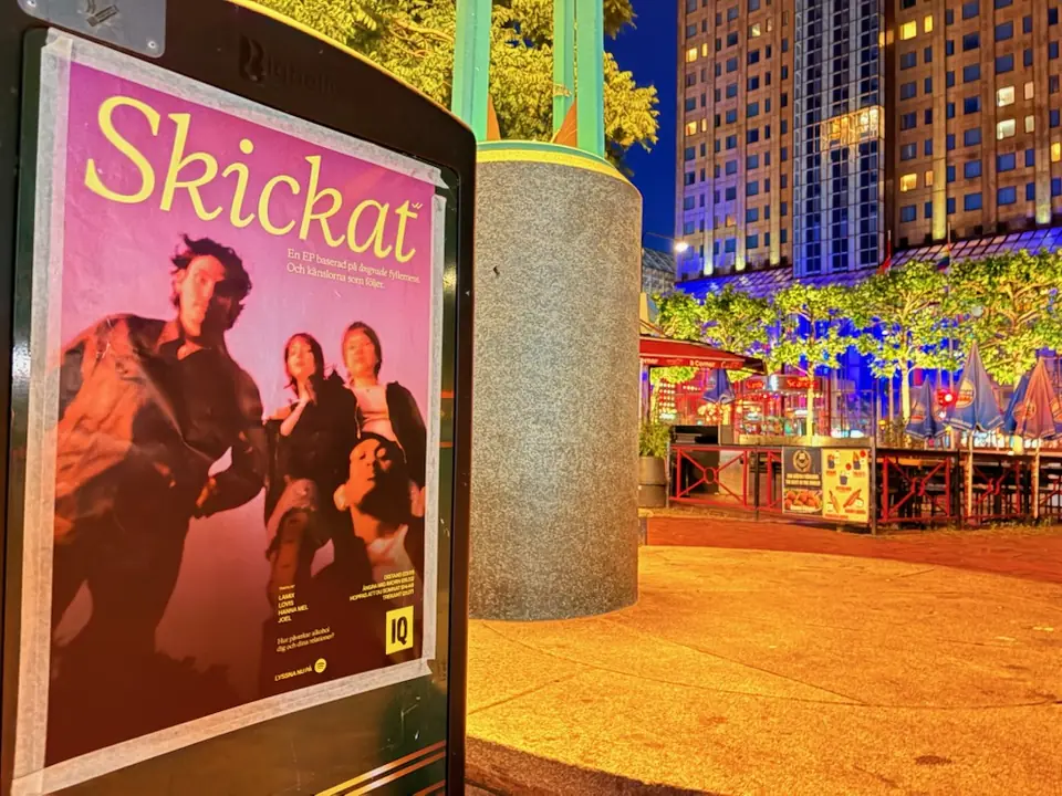 IQ:s affisch Skickat på en pelare vid ett torg
