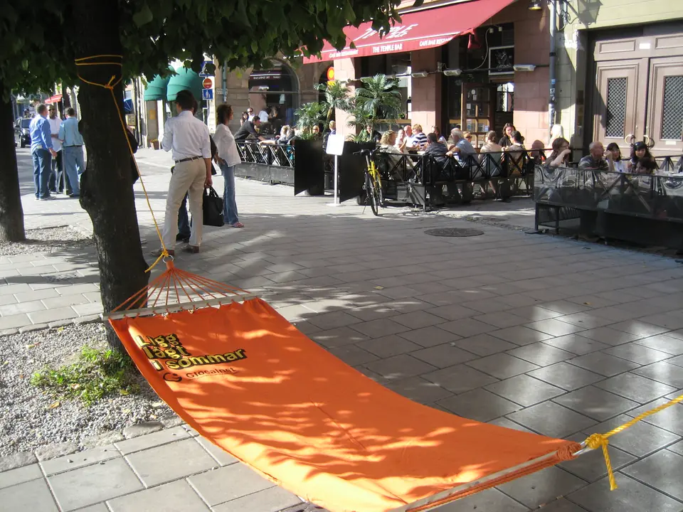 Orange hammock between trees at an outdoor café