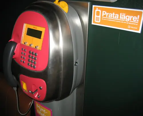 Talk quieter sticker in a phone booth