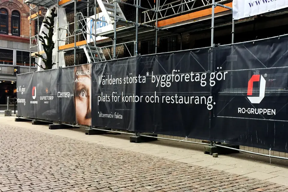 Byggvepa för RO-Gruppen på ett byggstängsel längs en gågata