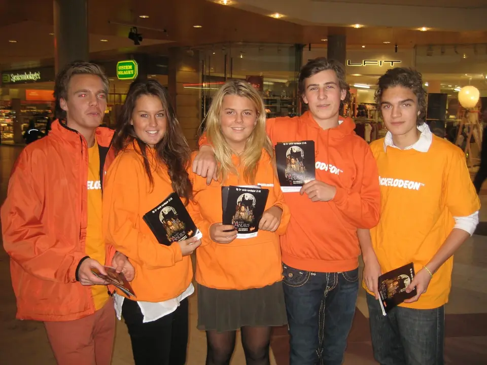 Street team i orange tröjor delar ut material