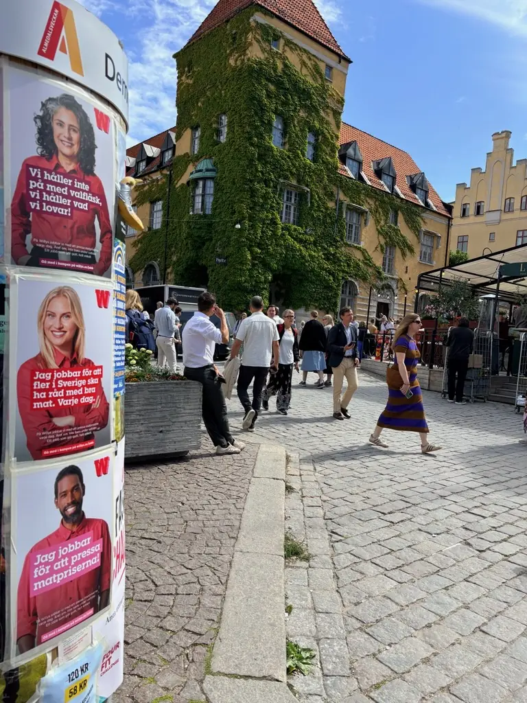 Willys-affischer på en affischpelare med Almedalsveckans logga på ett torg i Visby