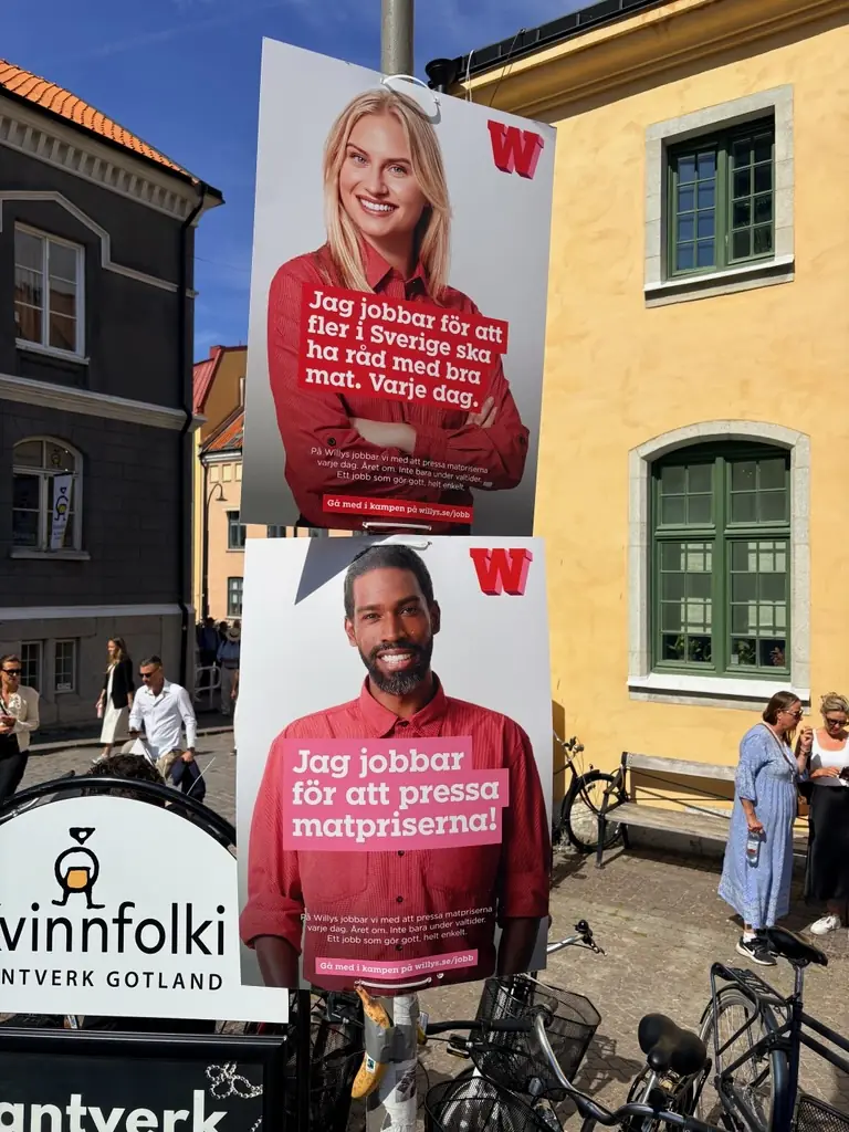 Två Willys-affischer på en stolpe i Visby innerstad